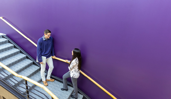 Two business students having a conversation on the stairs