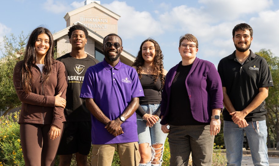 Dr. Kirk with a group of students at the entrance to Concordia University Texas