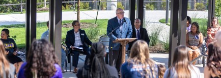 Dr. Christian delivering a speech to student and staff