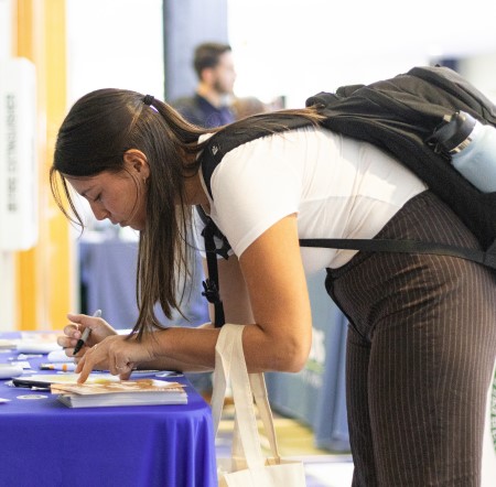 A student signing some forms