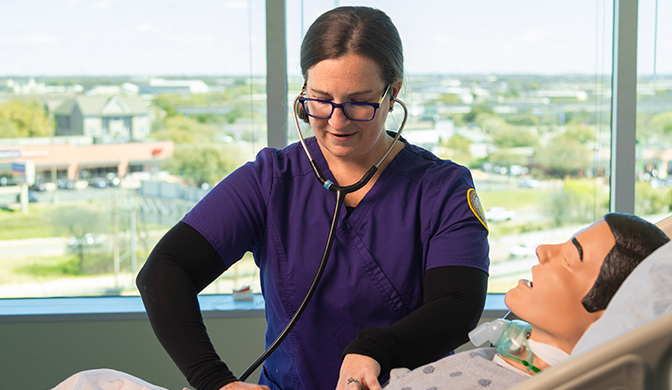 Concordia University Texas Nursing student working in a sim lab.