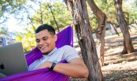 Student studing in a hammock on campus