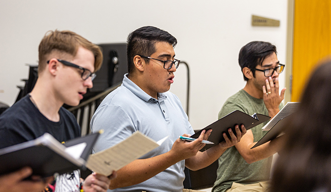 Three music major students singing with the University Singers