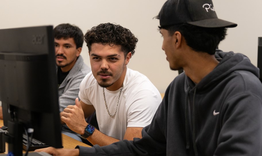A student helping his classmate with a project.