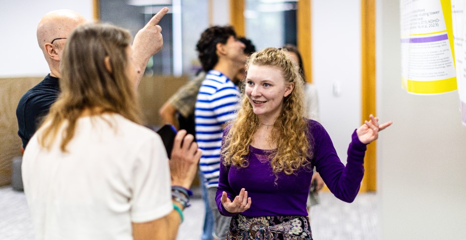 A Concordia University student explaining her project to professors.