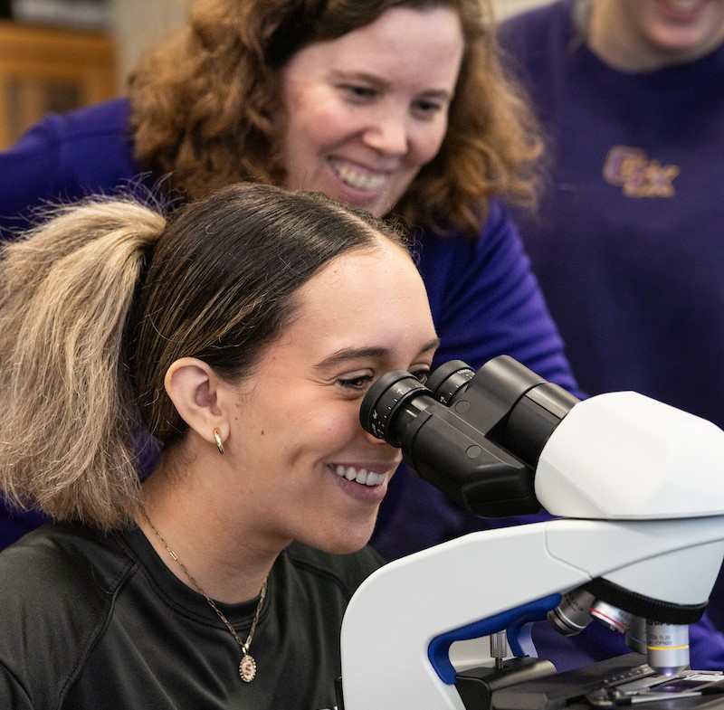 A student working with a microscope in a biology lab