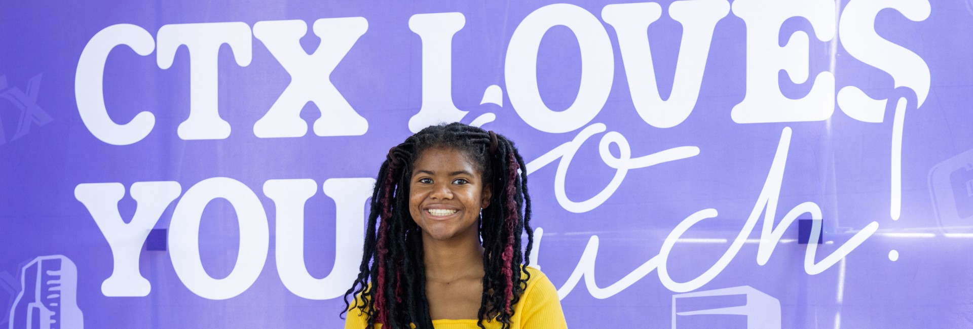 Student on Campus in front of the CTX loves you so much mural