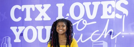 Student on Campus in front of the CTX loves you so much mural
