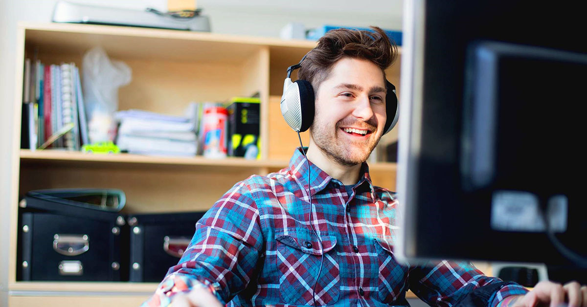 student on computer wearing headphones