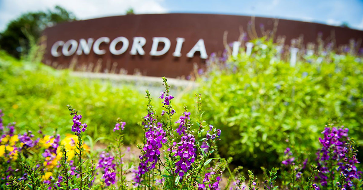 Concordia University entrance sign with wildflowers