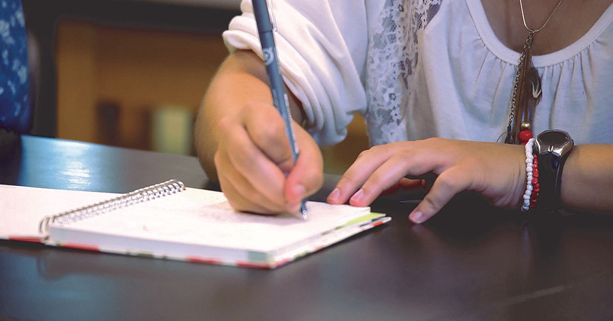 student writing in notebook