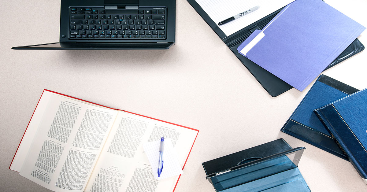 laptop, notebooks, dictionary on desk