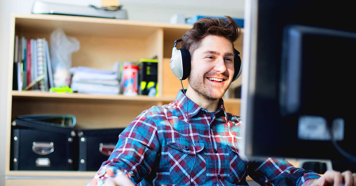 man on computer wearing earphones