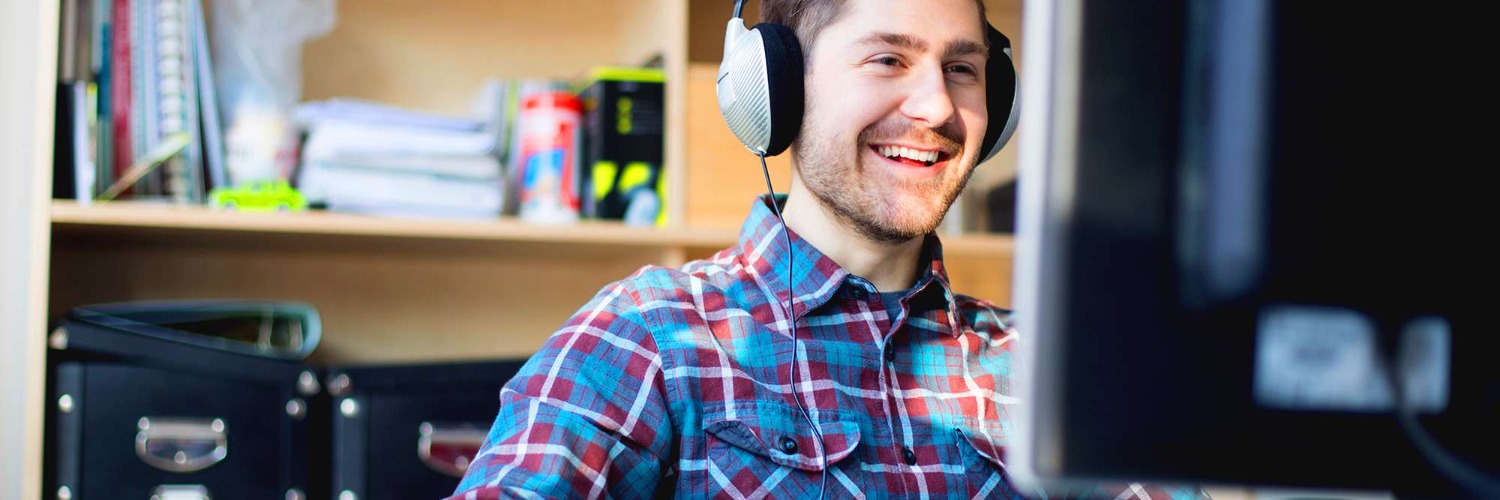 Man working on computer wearing headphones data scientist