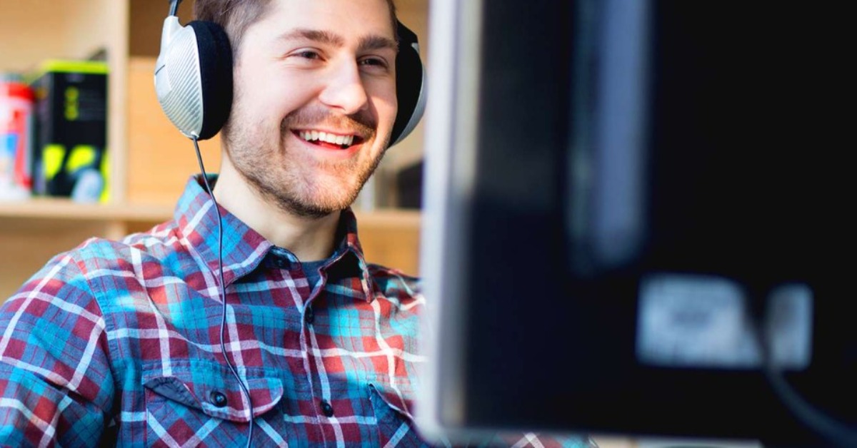 Man working on computer wearing headphones data scientist
