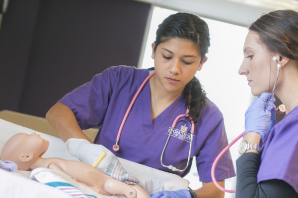 Nursing students learning in a sim lab.