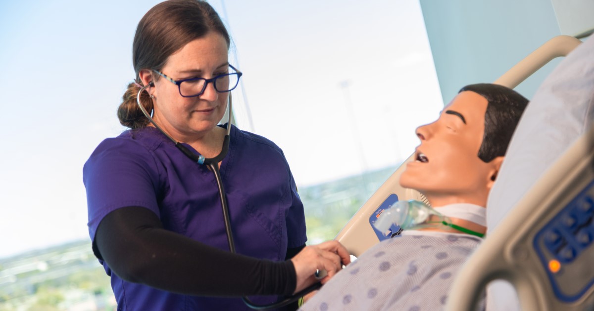 A nursing student practicing her skills on a sim patient.