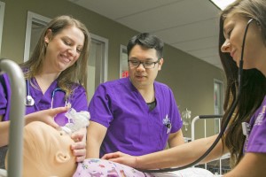 A trio of Concordia University Texas nursing students practicing with a simulated patient