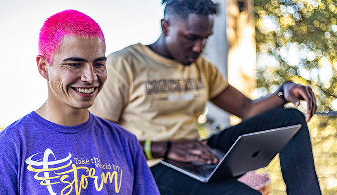 A pair of students studying on campus